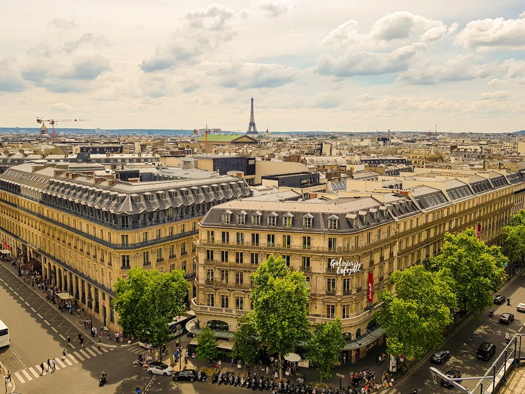 Aerial view of Paris with Galeries Lafayette and Eiffel Tower in the background.