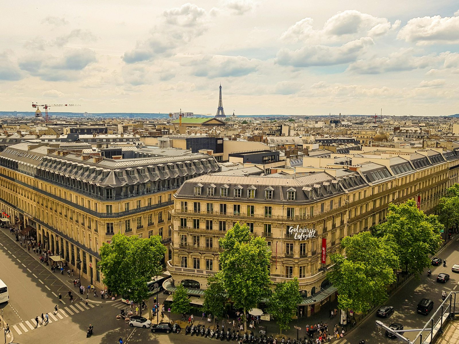 Aerial view of Paris with Galeries Lafayette and Eiffel Tower in the background.