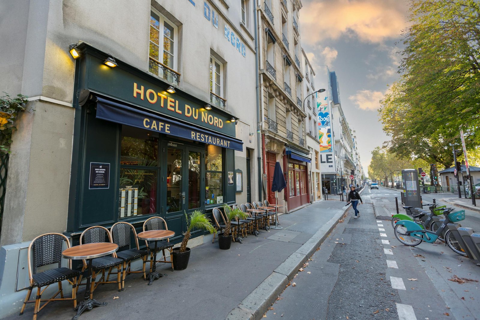 beautiful paris street with hotel du nord outdoor cafe seating and parked bikes. 7906591 scaled