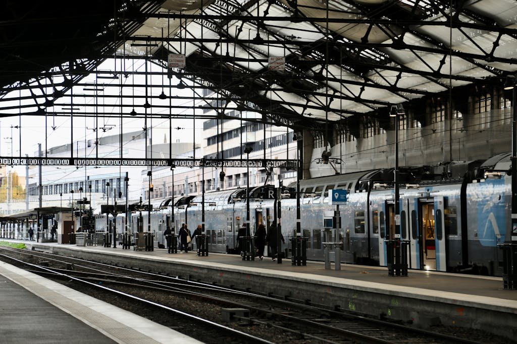 Train station in Paris, France, with people boarding trains. Urban transit scene.