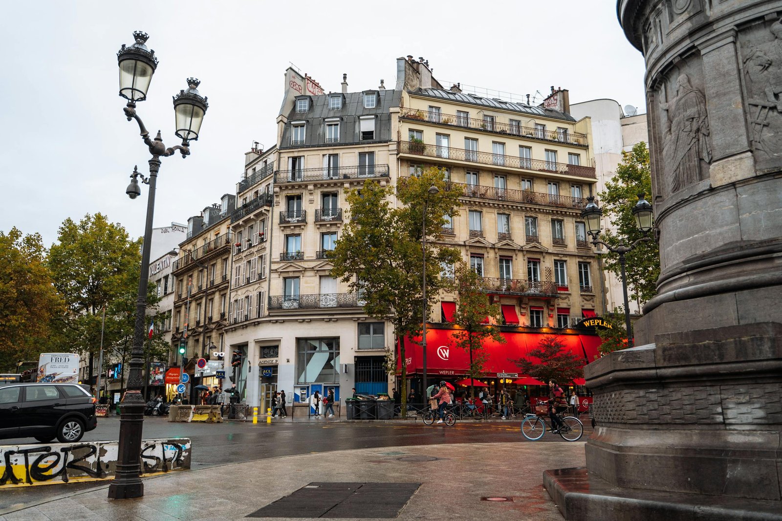 Vibrant urban scene in Montmartre, Paris showcasing classic architecture and bustling street life.