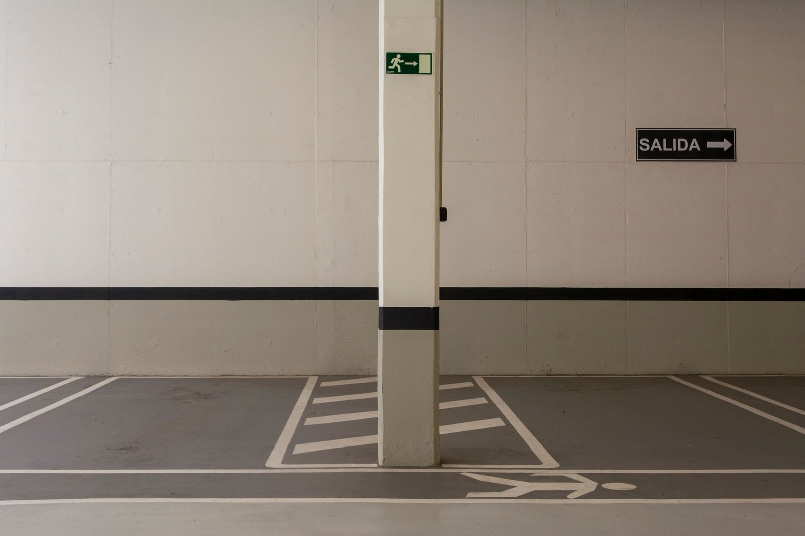 Aparcamiento subterráneo de líneas minimalistas con señales de salida y recorridos marcados
